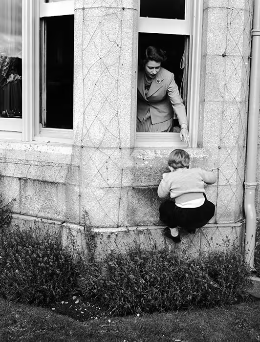 Another photo from the same sessions shows a young Charles climbing a wall to get to his mother