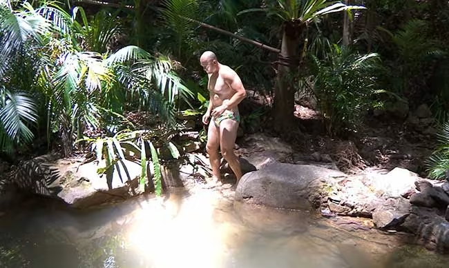 Mike donned tight swimming trunks in the jungle