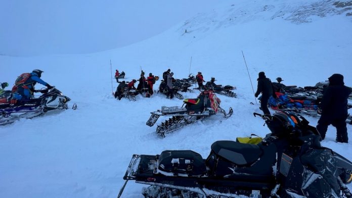 One dead and another missing after being buried by avalanche during snowmobile trip