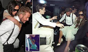 Victoria Beckham giggles behind her sunglasses as he RIDES piggy back on David 9833883