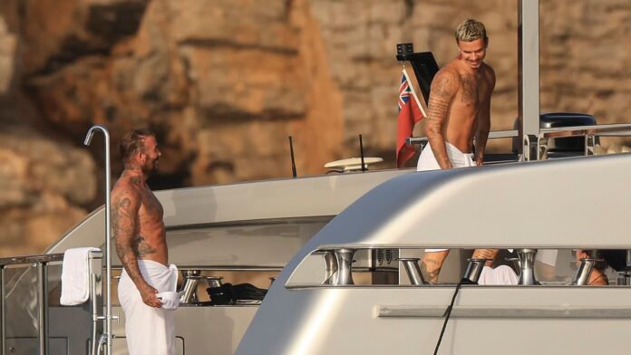 Romeo Beckham, 23, looks just like his famous dad David, 51, as they show off their shirtless tattooed torsos in matching towels on board Ibiza yacht with Victoria and Kim Turnbull__ 626262